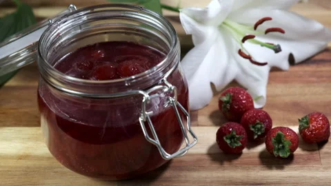 Man spooning strawberry jam/jelly into jar 4k 60fps Stock Footage