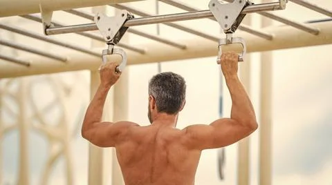 Man sportsman do pulling exercise. Man muscular back athlete doing pull up in Stock Photos