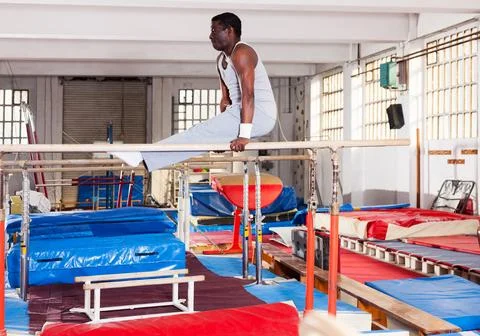 Man in sportswear doing exercises on parallel bars 스톡 사진
