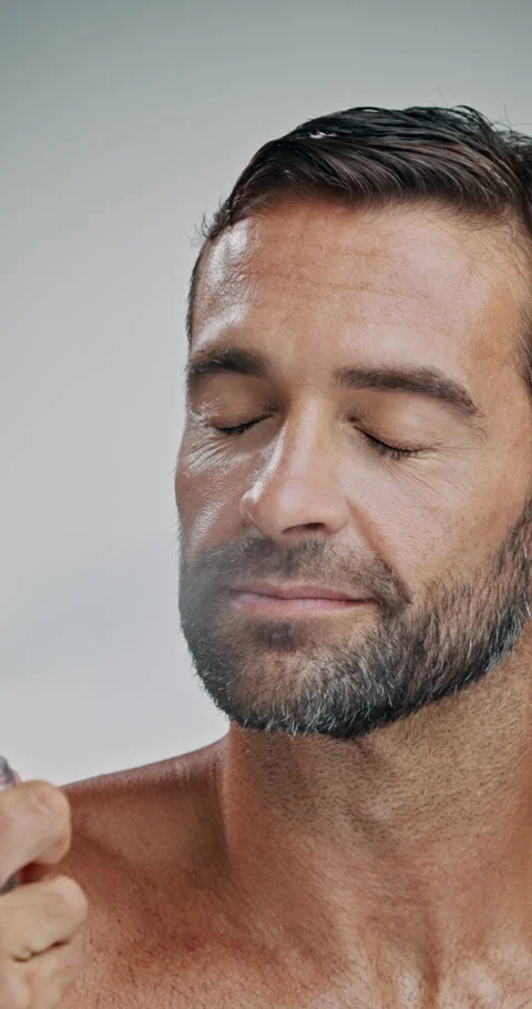 Man, spray and perfume in studio with cosmetics, aftershave and eyes closed for Stock-Footage 306460233