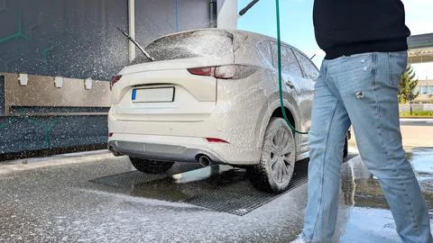 Man Spraying Active White Soap Foam On Luxury Modern SUV Fotos Stock