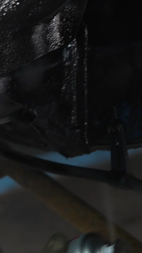 Man spraying black protective anti-corrosion coating onto car chassis part. Stock Footage 344364806