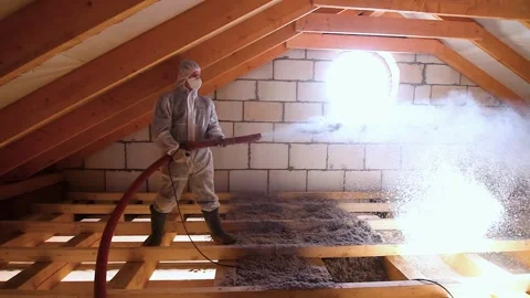 A man is spraying cellulose insulation in the attic of a house Stock Footage 144735699