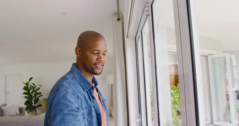 Man is spraying cleaner and is pulling rubber squeegee at sliding glass doors to Stock Footage 341468463