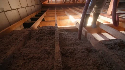 A man is spraying ecowool insulation in the attic of a house Stock Footage 169316937