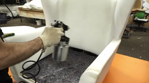Man spraying glue with a gun while making furniture Stock Footage 273142205