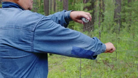 Man spraying his clothes with tick, mosquito repellent Video stock 203890499