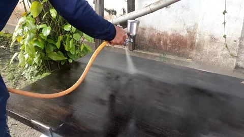 Man Spraying Paint on Surface Using Spray Gun – Close-Up of DIY Work Video stock 309467171