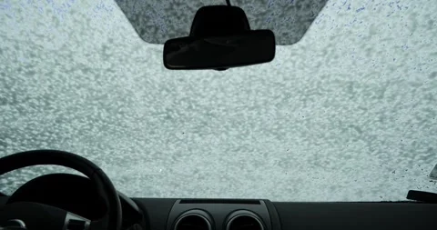 Man spraying soap foam on car windshield view from inside car POV Stock Footage 338338869