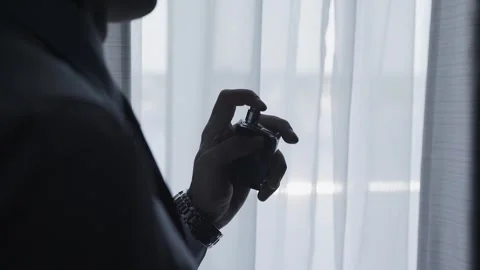 A man sprays perfume on himself Stock Footage 306148612