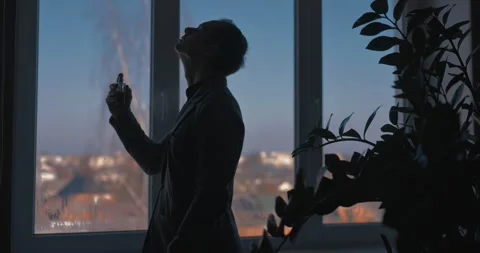 A man sprays perfume while standing by a window in a classic suit Stock-Footage 330308686