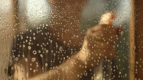 Man sprays soap solution on a window (defocused) Stock Footage 68488578