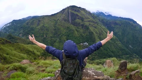 Man spread arms to sides while sitting on top mountain. Having overcome Video stock 277843615