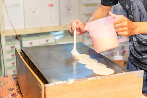 The man spread the batter in the pan for make tokyo pancake. Stock-Fotos