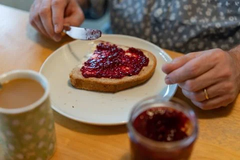 A man spread jelly on his bread Stock Photos
