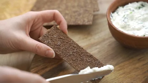 Man spreading butter on rye dry toast with a knife. Person spreading creamy Stock Footage 149025745