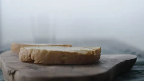 Man spreading chocolate hazelnut spread on ciabatta slice on olive wood board Stock Footage 181023743