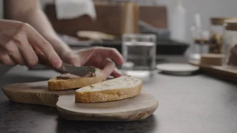 Man spreading chocolate hazelnut spread on ciabatta slice on olive wood board Stock Footage 181029050