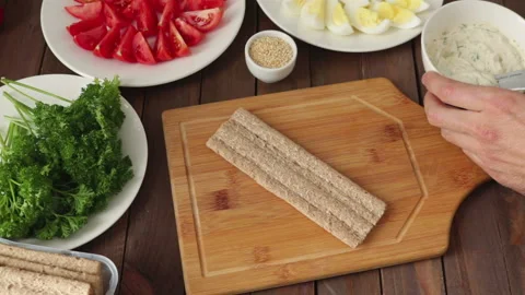 Man spreading cream cheese on crispbread making healthy sandwcih Stock-Footage 119801949