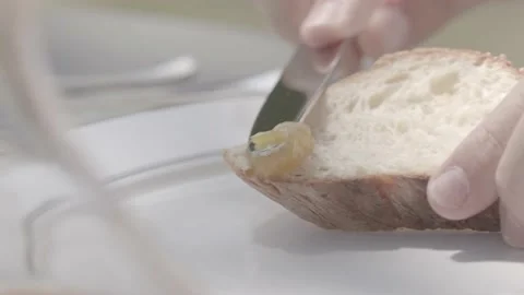 A man spreading jam on bread outside, close up, sunny day Stock Footage 135396955