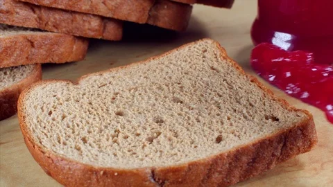 A man spreading jam over a brown bread base Stock Footage 113335119