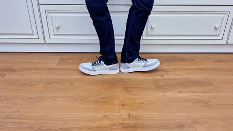Man Spreading Legs in Different Directions on Indoor Wooden Floor 動画素材 336298454