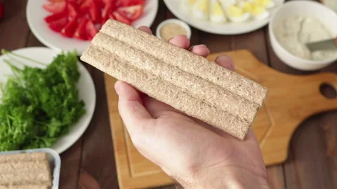 Man spreading soft cream cheese on crisp bread making healthy sandwich close up Stock Footage 120564012