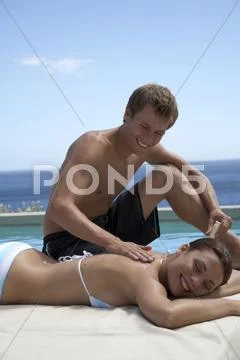 Man spreading suncreme on woman´s back Stock Photos