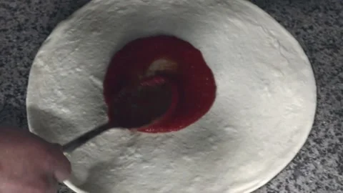 Man spreading tomato paste on pizza dough 库存影片 200204173