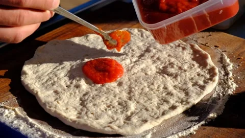 Man Spreading Tomato Sauce on Pizza Dough, 4K Stock Footage 136449778