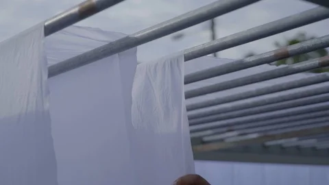 Man Spreading white material sheet of fabric cloth outside Stock Footage 108798273