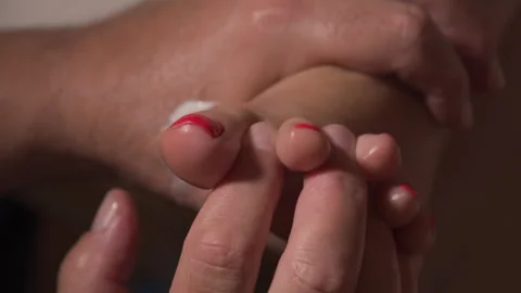 Man spreading woman's toes while giving her a foot massage Stock Footage 297031339