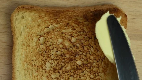 Man spreads butter on bread with a knife Stock Footage 123281155