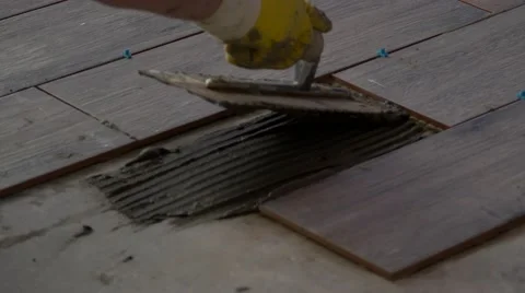 Man spreads mortar while laying tile, 4K Stock Footage 59521277