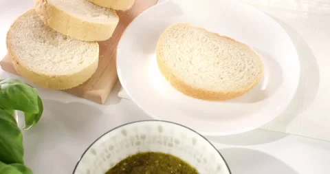 Man spreads pesto sauce on bread with a knife. close-up. angle view. Stock Footage 243773827