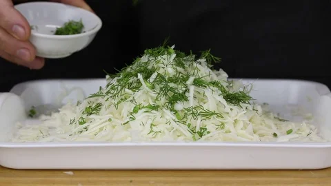 A man sprinkles thinly sliced cabbage Stock Footage 121705127
