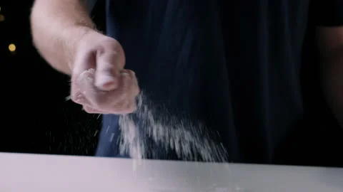 Man sprinkling flour on surface Stock Footage 132798529