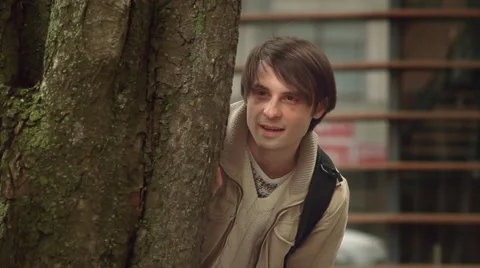 Man Spying Hiding Behind a Tree 스톡 동영상 62994790