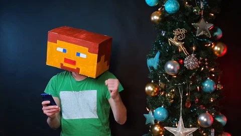 A man in a square hat with a painted face on his head uses a smartphone. Stock Footage 121253426