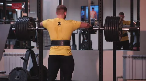 The man squats with a barbell Stock Footage 62229563