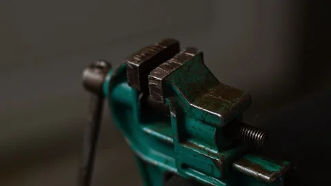 A man squeezes a black wire in a small vice Stock-Footage 138287498
