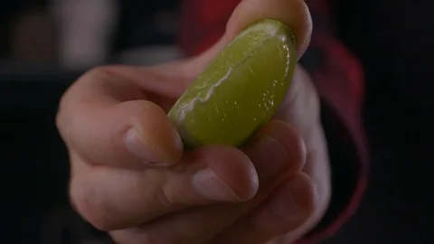 Man squeezes juice from lime macro view in the kitchen slow motion Video stock 121417265