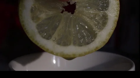 A man squeezes lemon juice into a cup. The lemon is fresh and juicy, it can b Stock Footage 109421253