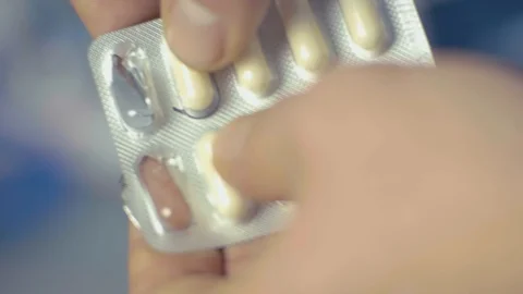 The man squeezes the pill from the package Stock Footage 85899275
