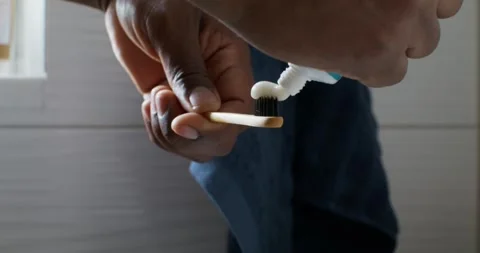 A man squeezes toothpaste onto a brush Stock Footage 307534899