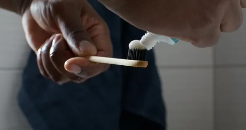 A man squeezes toothpaste onto a brush Stock Footage 307535196