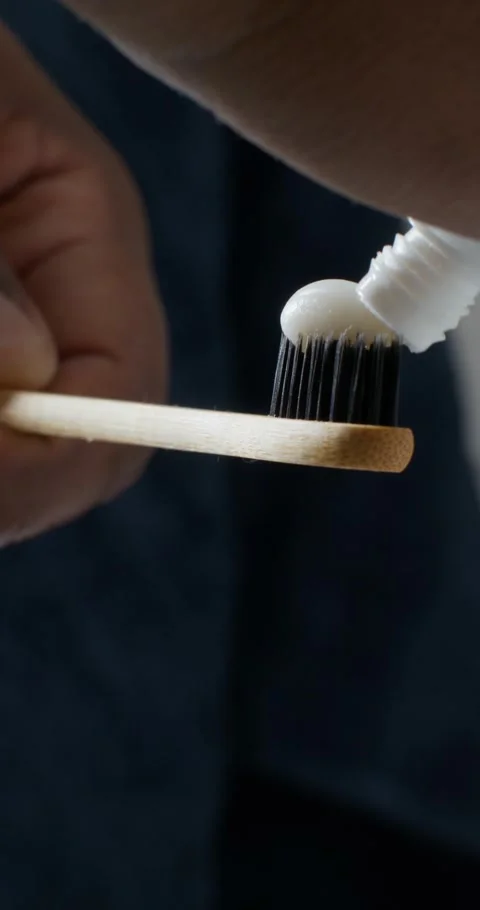 A man squeezes toothpaste onto a brush Stock Footage 313085398