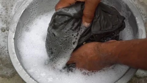 Man Squeezing and Cleaning Dark Garment in Thick Detergent Foam Water. Stock Footage 337507304