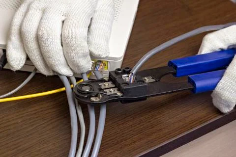 A man is squeezing a chip on a network cable, a modem, the Internet, a close-up Foto stock
