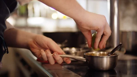 Man is squeezing a fresh lemon over a delicious meal Stockbeeldmateriaal 118973617